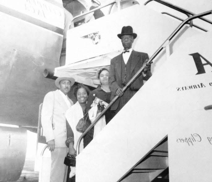 Archival photograph of COGIC leaders on airplane stairs.